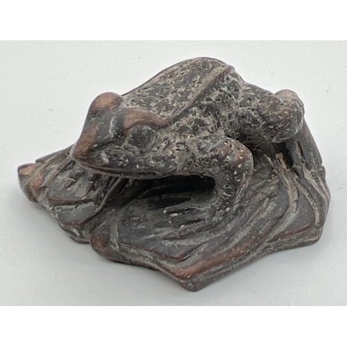 1246 - A small carved dark wood figure of a frog. Approx. 2.5cm tall x 4.75cm long.