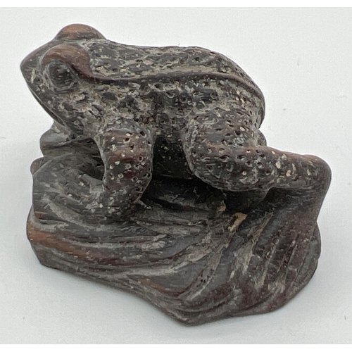 1246 - A small carved dark wood figure of a frog. Approx. 2.5cm tall x 4.75cm long.