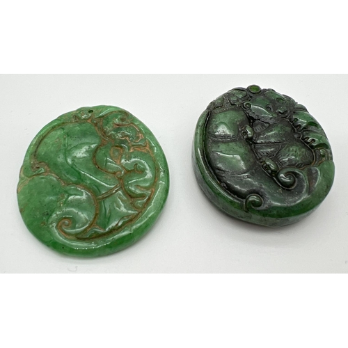 1247 - 2 Oriental carved roundels, possibly jade, each with small hole for hanging. Carved detail to both s... 