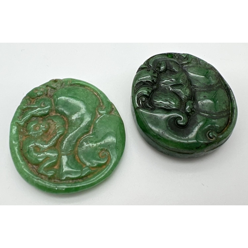 1247 - 2 Oriental carved roundels, possibly jade, each with small hole for hanging. Carved detail to both s... 