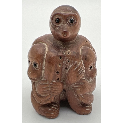 1248 - A carved wooden netsuke of monkeys and an octopus. Toggle holes to underside. Approx. 4.5cm tall.