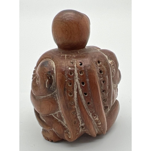 1248 - A carved wooden netsuke of monkeys and an octopus. Toggle holes to underside. Approx. 4.5cm tall.