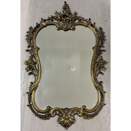 1390 - A antique gold coloured metal framed Rococo style shaped wall hanging mirror. With floral and scroll... 