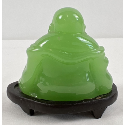 1256 - A small carved green jade sitting Buddha figure on a small wooden stand. Figure approx. 5.5cm tall.