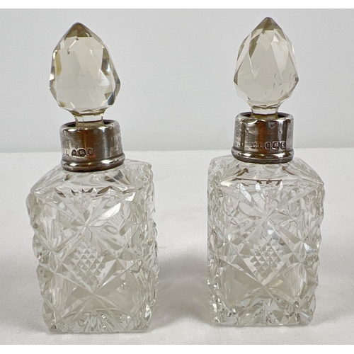 1187 - A small pair of antique cut glass scent bottles with silver collars. Hallmarked London 1923. Approx.... 