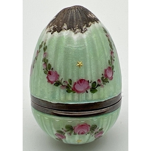 1185 - A 935 silver and green guilloche egg shaped trinket with floral swag detail. Hinged lid has interior... 