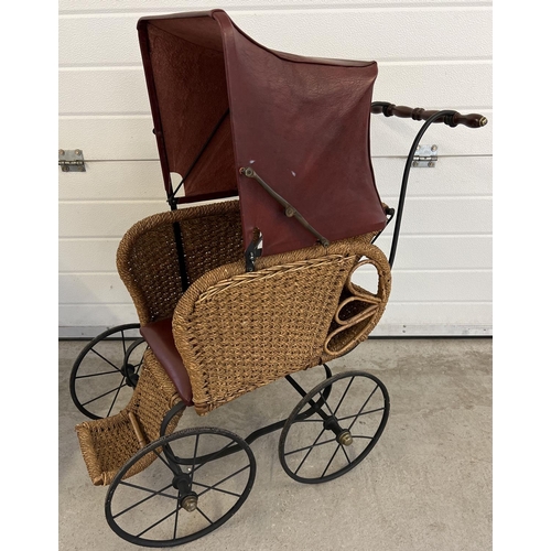 1316 - A large reproduction basket weave and leather dolls pushchair with black metal frame & wooden handle... 