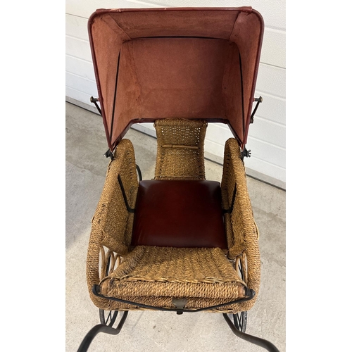 1316 - A large reproduction basket weave and leather dolls pushchair with black metal frame & wooden handle... 