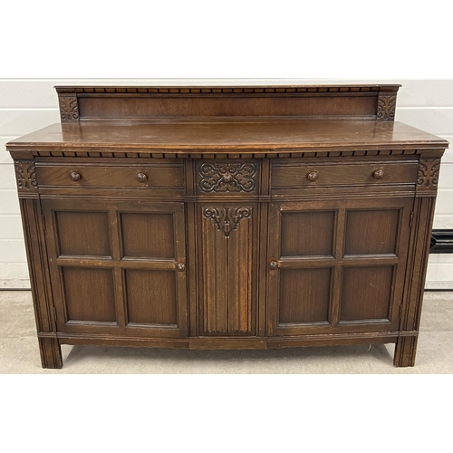 1398 - A vintage dark wood Old Charm style sideboard with carved detail and panelled doors. 2 cupboards to ... 