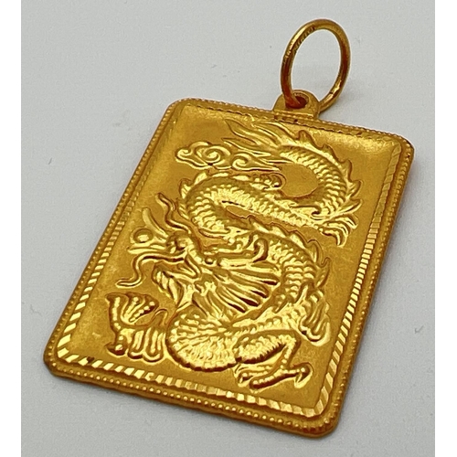 164 - A 22ct gold large square pendant with oriental design dragon to front and geometric sun ray design t... 