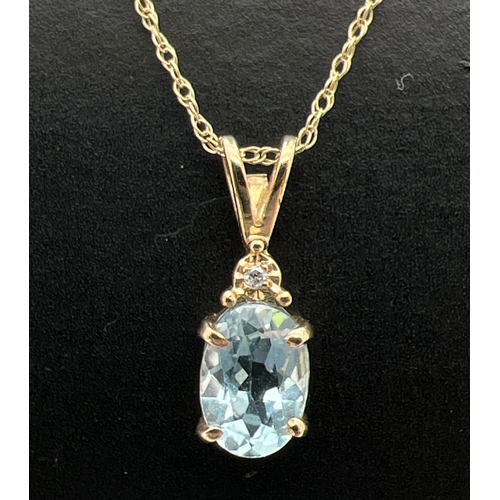 1001 - A 9ct gold blue topaz and diamond set drop pendant on an 18