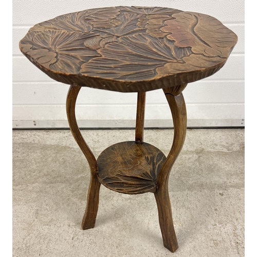 1389 - A vintage Oriental style occasional table with carving of foliate design to top and undershelf. Shap... 