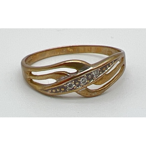 1027 - A 9ct gold diamond set crossover design band style ring. Open work crossover central design set with... 