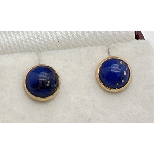 1029 - A pair of 18ct Egyptian gold stud earrings set with lapis lazuli. Gold marks to earring posts and mo... 