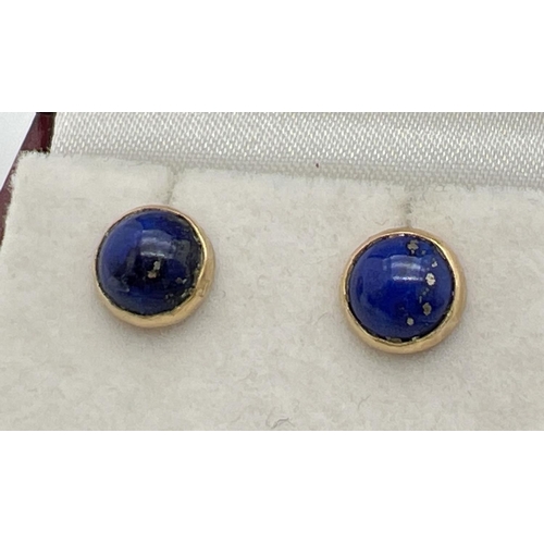 1029 - A pair of 18ct Egyptian gold stud earrings set with lapis lazuli. Gold marks to earring posts and mo... 