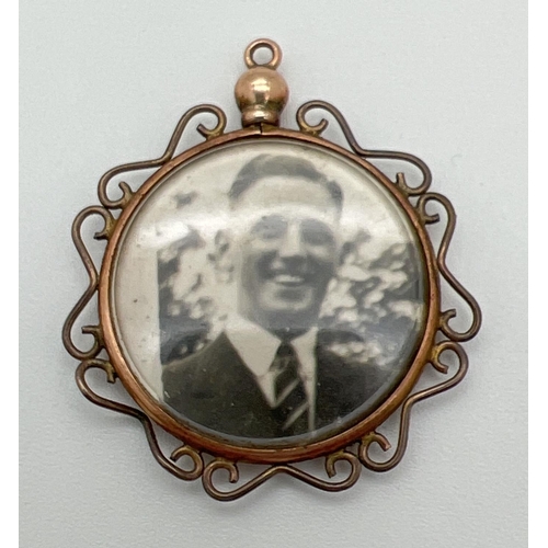 1036 - A vintage 9ct gold double sided circular photo pendant with decorative scroll detail to edges. Hallm... 