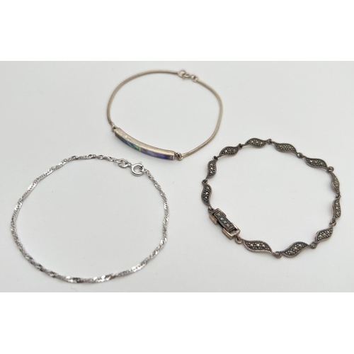 1039 - 3 silver bracelets. An identity style set with Paua shell, a wave link bracelet set with marcasite s... 