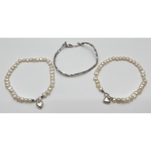 1044 - 2 matching freshwater pearl and silver bracelets with heart charms, together with a plaited design s... 