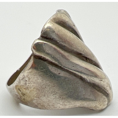 1051 - A contemporary design large silver dress ring. Rough grooved detail to top of ring. Worn 925 mark to... 