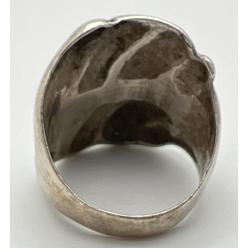 1051 - A contemporary design large silver dress ring. Rough grooved detail to top of ring. Worn 925 mark to... 