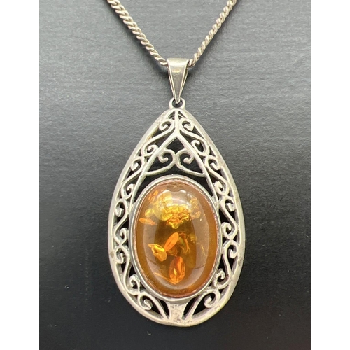 1052 - A modern design teardrop shaped amber set pendant with pierced design mount. On a 16 inch curb chain... 