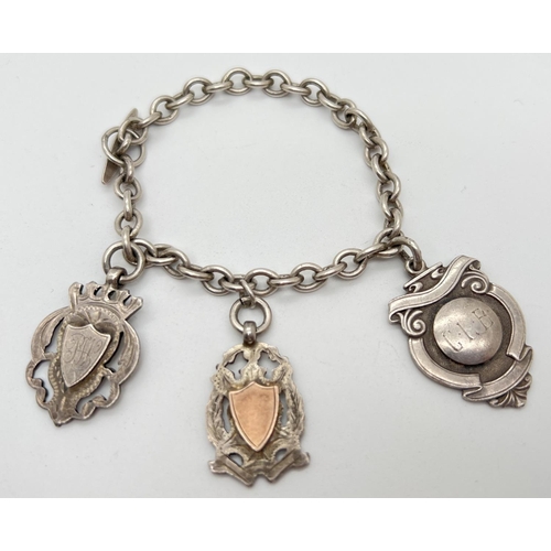 1056 - A vintage sterling silver charm bracelet with t bar style clasp and 3 silver shield medallions. Init... 