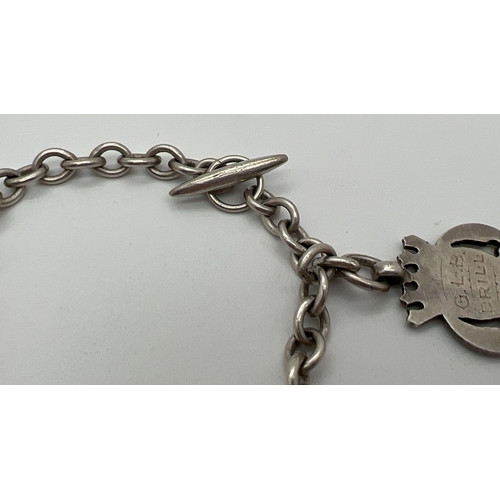 1056 - A vintage sterling silver charm bracelet with t bar style clasp and 3 silver shield medallions. Init... 