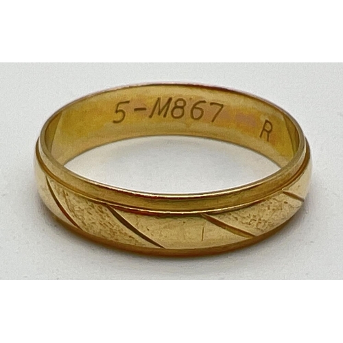 1061 - A vintage 18ct gold wedding band with diagonal line pattern throughout. Hallmarks to inside of band ... 