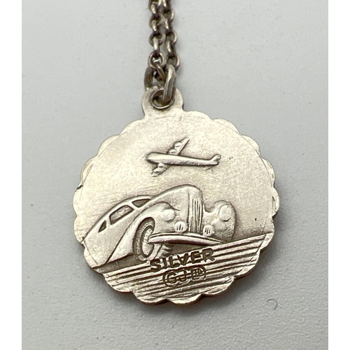 1064 - A vintage silver St. Christopher circular shaped pendant with Art Deco car and aircraft detail to ba... 