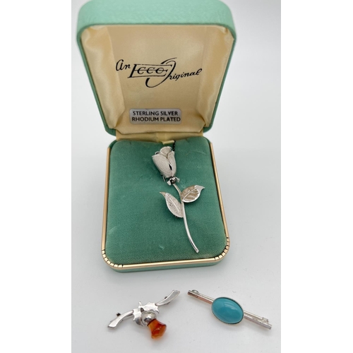 1068 - 3 silver brooches. A boxed Ecco original single stem rose, a bar brooch set with an oval of turquois... 