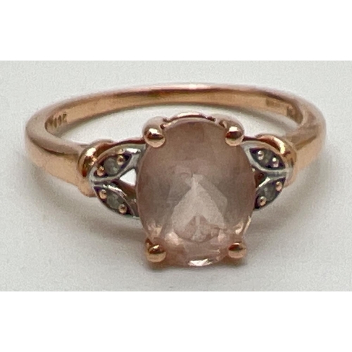 1083 - A 9ct rose gold, morganite and diamond dress ring. Central oval cut morganite with 2 small diamonds ... 