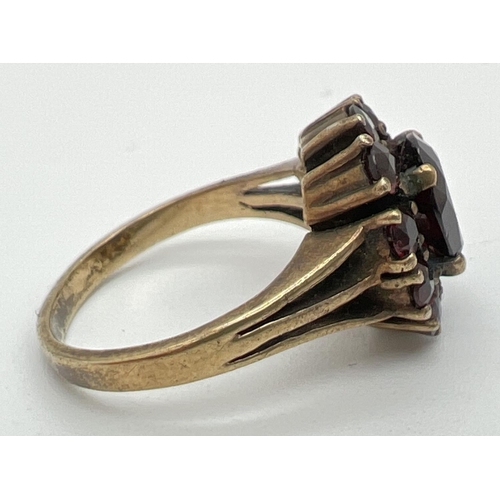 1094 - A vintage silver cocktail style ring set with Garnets. oval cut central garnet surrounded by 10 smal... 