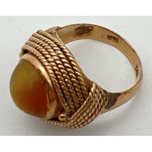 1105 - A vintage 18ct gold wrap over style pale yellow cats eye stone set dress ring. Rope design wrap over... 