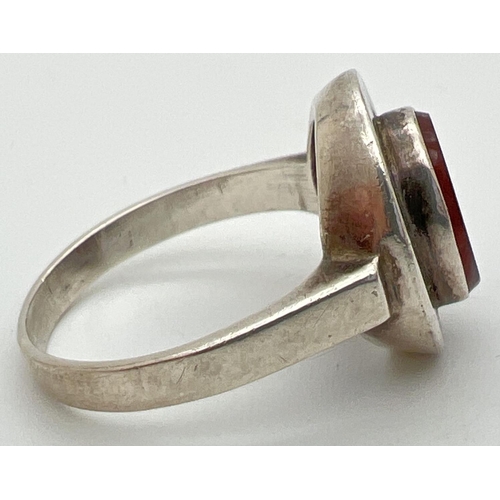 1109 - A silver contemporary style oval shaped ring set with carnelian. 925 stamped to inside of band. Size... 