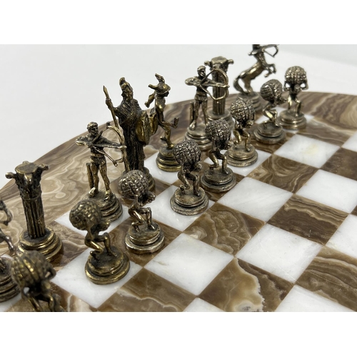 1344 - A vintage circular shaped marble chess board with cast metal Greek Mythology chess pieces (2 a/f). B... 