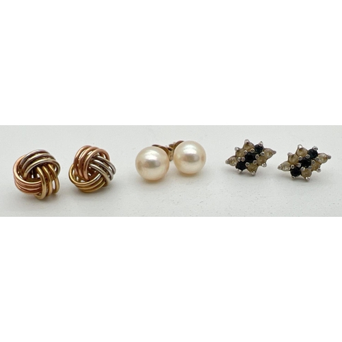 1110 - 3 pairs of gold stud style earrings. A pair of cream pearl studs, a pair of tri-coloured gold knot e... 