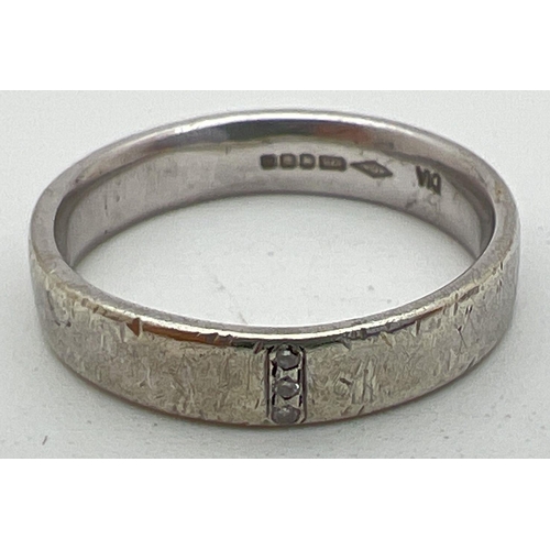 1113 - A 9ct white gold wedding ring set with 3 small round cut diamonds. Full hallmarks to inside of band.... 