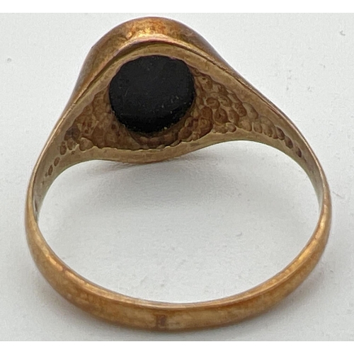 1115 - A small 9ct gold signet style ring set with an oval of black onyx. Full hallmarks to inside of band.... 