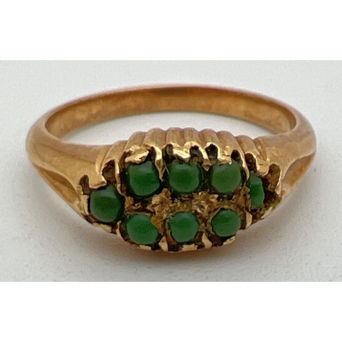 1116 - An antique 18ct gold dress ring set with 8 small round natural green stones. Not hallmarked, tests a... 