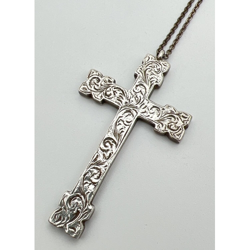 1117 - A large vintage heavy silver cross shaped pendant with floral engraved decoration to front. On a 22