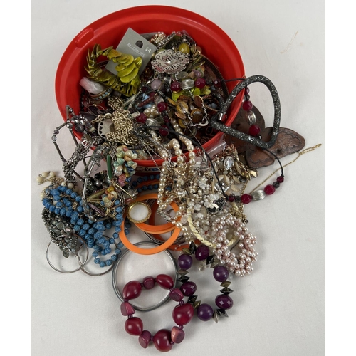 1129 - A tub of assorted vintage and modern costume jewellery to include bangles, necklaces, rings and brac... 