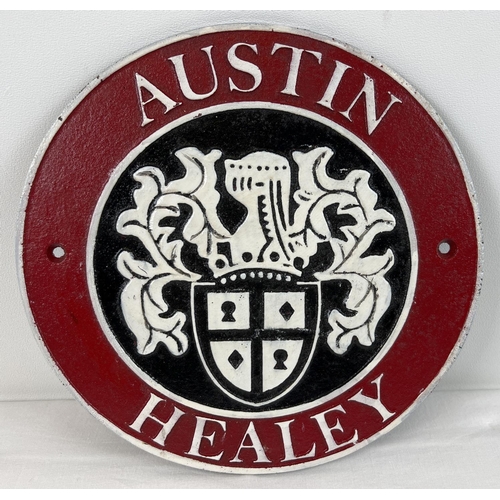 1328 - An Austin Healey circular shaped painted cast iron wall plaque. In red, black and white and with fix... 