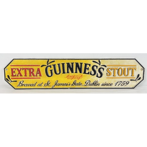 1240 - A painted cast metal Guinness Extra Stout wall plaque with fixing holes. Approx. 56.5cm long.