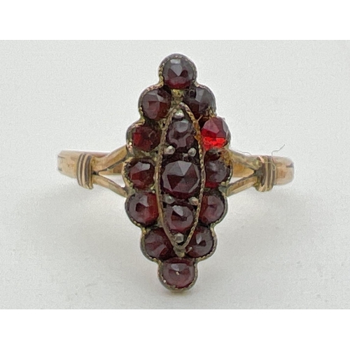 1138 - A vintage garnet dress ring with marquise shaped mount set with small round cut garnets. Ring shows ... 