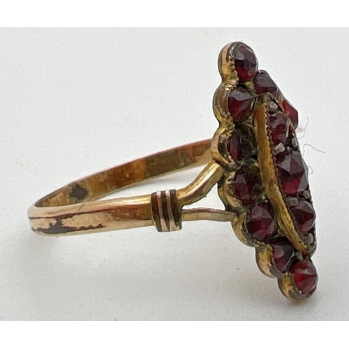 1138 - A vintage garnet dress ring with marquise shaped mount set with small round cut garnets. Ring shows ... 