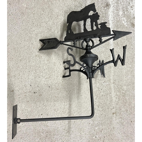 1245 - A black painted cast metal weathervane with Blacksmith shaped finial. With wall mounting bracket. Ap... 