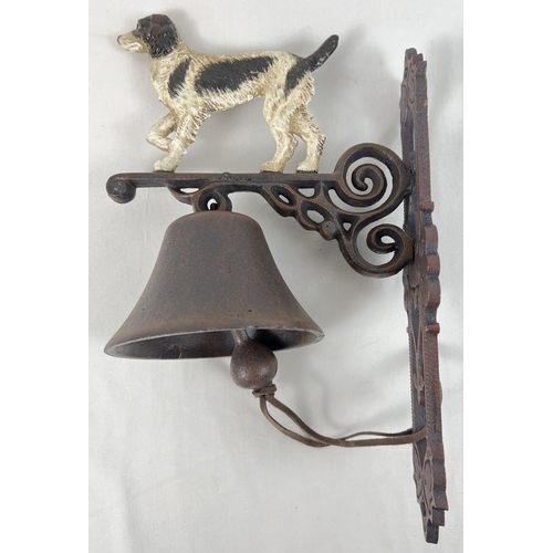 1246 - A cast iron wall mountable garden bell with painted dog detail. Approx. 35cm tall.