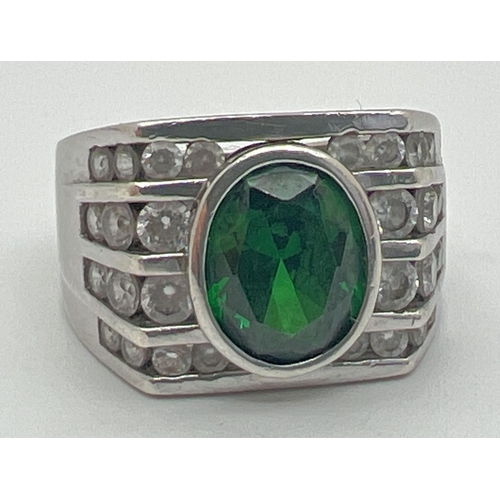 1144 - A modern Art Deco design silver cocktail ring. Set with an oval cut central green stone with 4 rows ... 