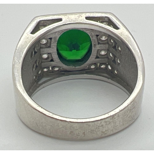 1144 - A modern Art Deco design silver cocktail ring. Set with an oval cut central green stone with 4 rows ... 