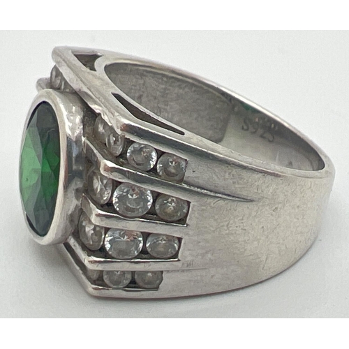 1144 - A modern Art Deco design silver cocktail ring. Set with an oval cut central green stone with 4 rows ... 